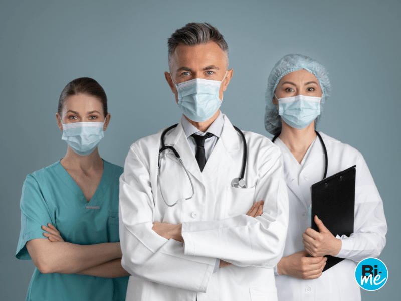three doctors with masks on looking in the same direction with their arms folded