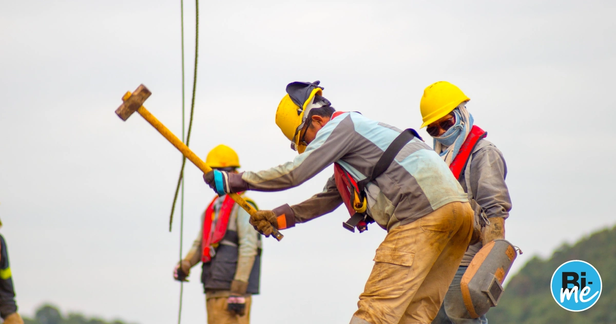 three contractors wokring on a construction sites with yellow helmets